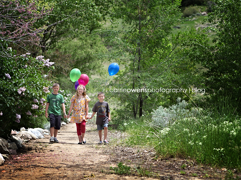 three kids walking with balloons in salt lake city