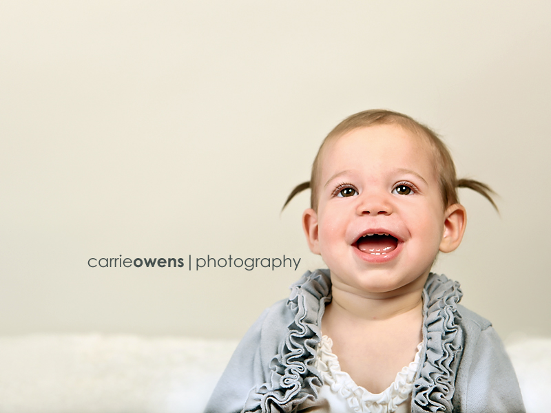 sandy utah photographer captures smiling one year old girl with pigtails