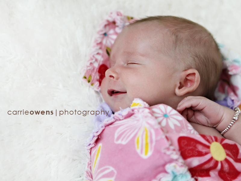 newborn girl smiling in pink quilt in salt lake city utah