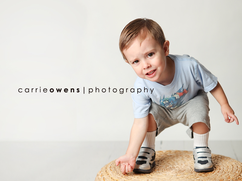 salt lake city utah child photographer Carrie Owens captures cute young boy as he warms up to the camera in the studio