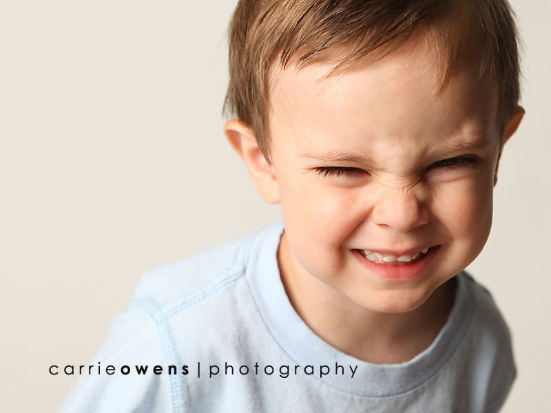 salt lake city utah child photographer Carrie Owens captures hilarious young boy as he warms up to the camera in the studio