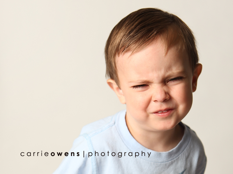 salt lake city utah child photographer Carrie Owens captures a silly and sweet young boy as he warms up to the camera in the studio